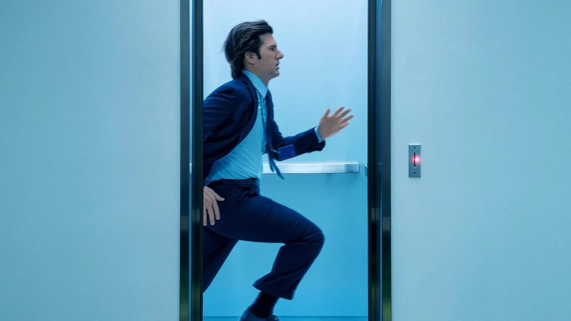 Cena da série Ruptura: funcionário da Lumon atravessando a porta do elevador